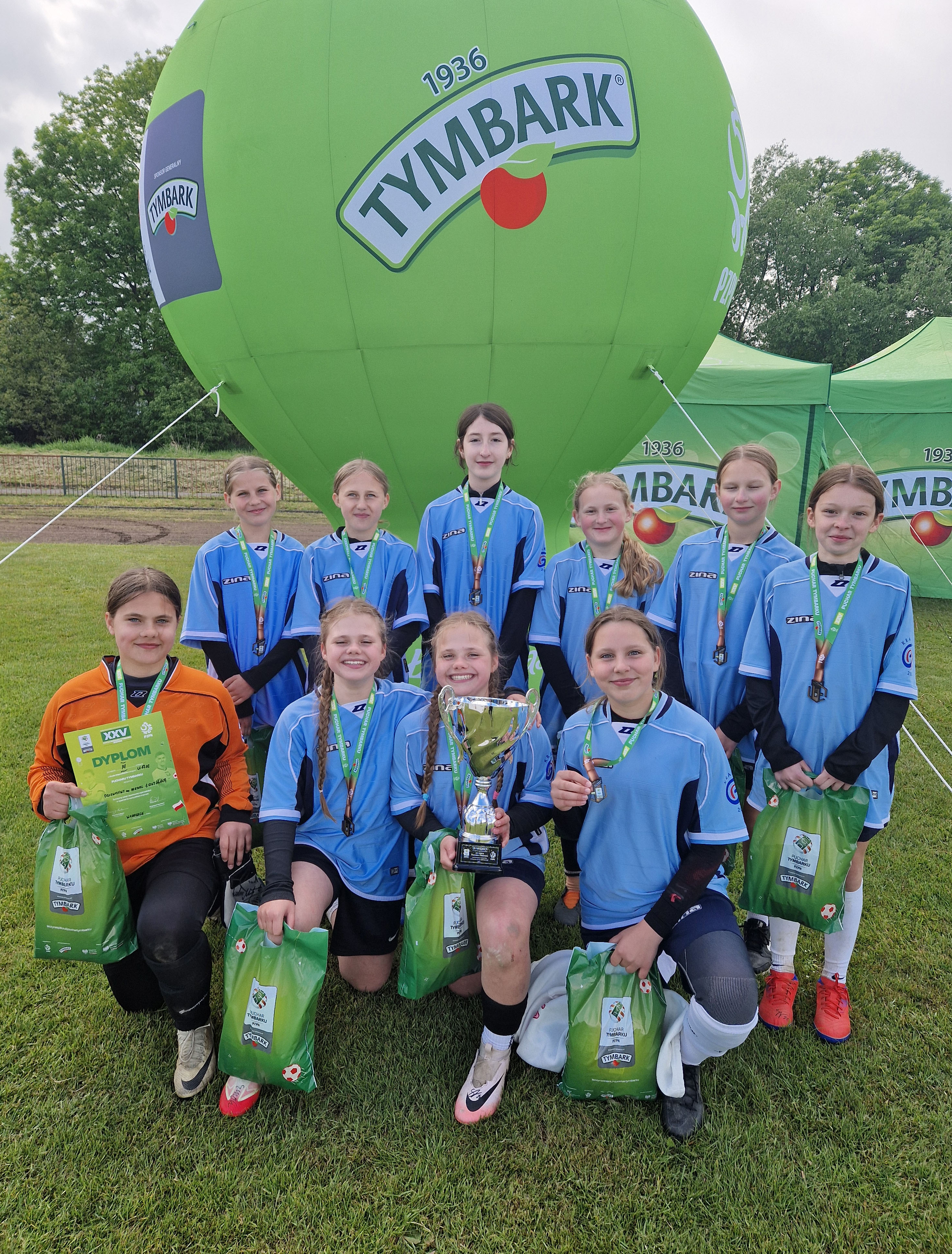 Zdjęcie przedstawiajace zawodniczki na tle balonu reklamowego "Tymbark"